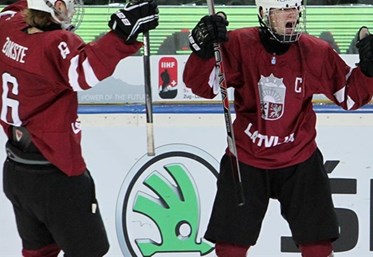 ZUG, SWITZERLAND - APRIL 16: Latvia's Kristaps Zile #7 celebrates with Karlis Cukste #6 after a first period goal against Canada during preliminary round action at the 2015 IIHF Ice Hockey U18 World Championship. (Photo by Francois Laplante/HHOF-IIHF Images)